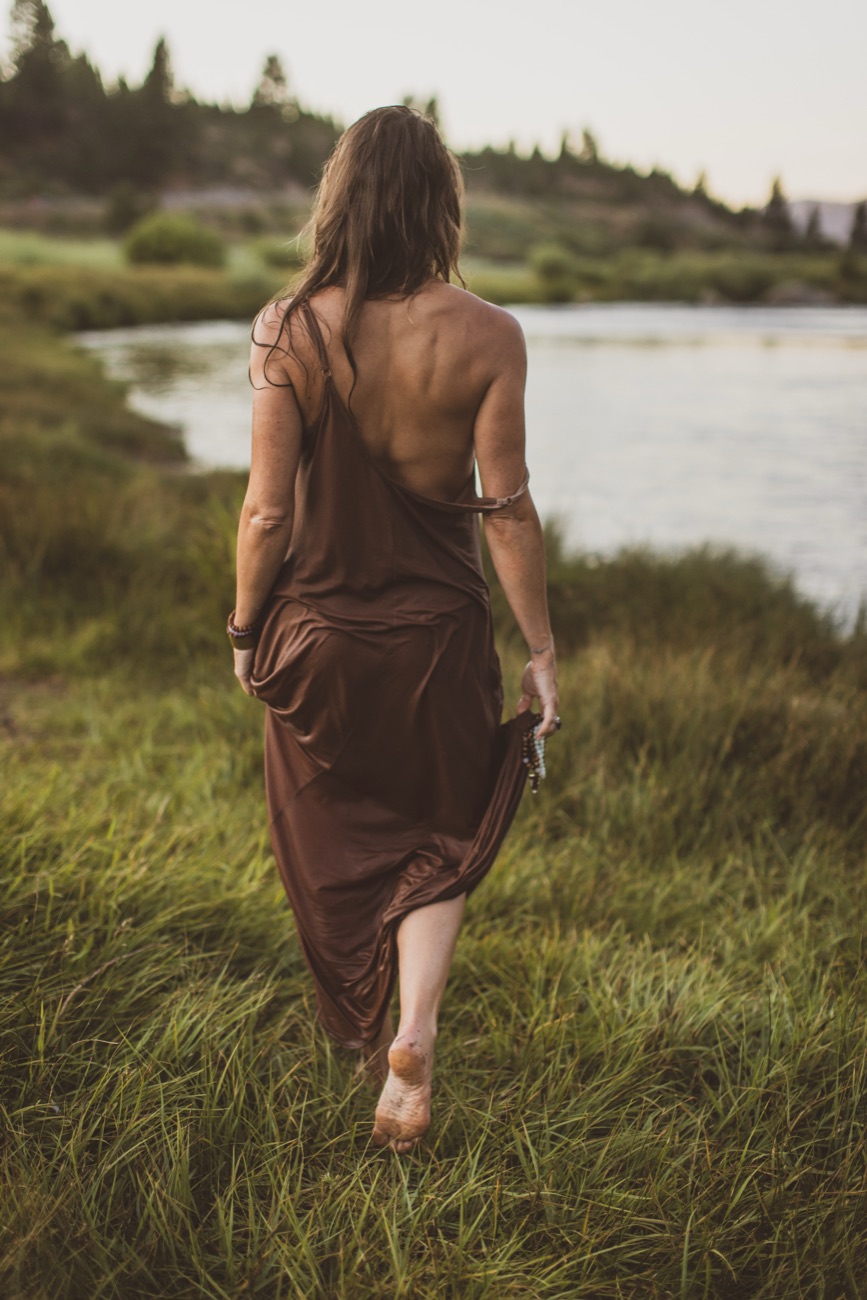 Kaila walking a riverbank at dusk