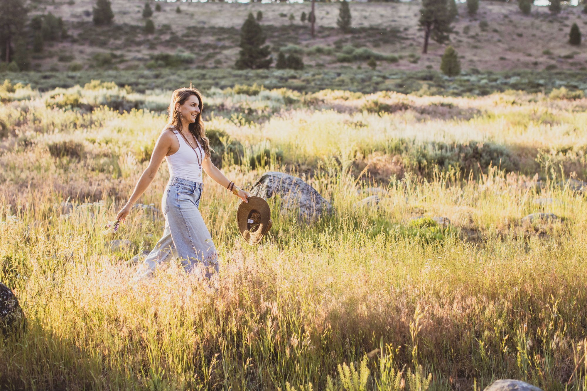 Kaila Leilani walking through a sunlit meadow at golden hour